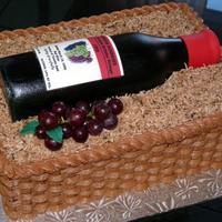 Wine Bottle In Basket 50/50 wine bottle with edible image label on buttercream basketweave cake with coconut filler.