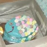 My Daughter's First Cake :) My 9 year old daughter made this fish cake for her dad last week for his birthday. It is white cake with bc frosting. The scales are Necco...