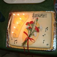 70Th Birthday Cake For Music Lover hand made sugar paste flowers adorn the O on 70. Musical notes for happy birthday on top corner