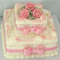 Pink Roses And Bows White cake filled with strawberry/rose-flavored mousse and iced with buttercream. The bows and ribbons are fondant. Thanks to LeckiAnne for...