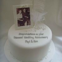 Diamond Wedding Photoframe is modelling paste, picture is edible. Scattered diamonds are edible too. Added feathers and cake jewelry for glamour.