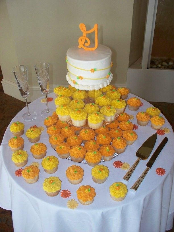 Cupcake Wedding Cake 6" cake for cutting, the rest cupcakes. All with tiny fondant flowers.