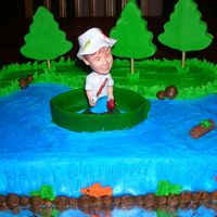 Fisherman 1/4 sheet cake. Devils food with buttercream dream icing. Fisherman was a bobble head. I made the trees, boat and log with the turtle out...