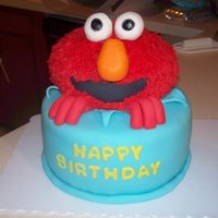 Elmo! This is a cake I made for a 1st birthday. The cake is covered in MMF. Elmo is made from cereal treats and covered in buttercream piped with...