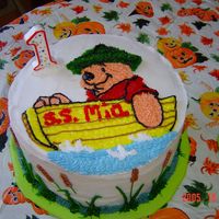 Uss Pooh Winnie the Pooh in a boat with cat's tails around sides of cake.