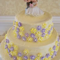 My First Wedding Cake Vanilla cake with vanilla buttercream and strawberry and lemon curd filling. Decorated with lilac and yellow royal icing flowers.