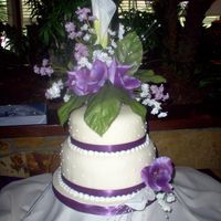 Wedding In Purples yellow cake iced with BC covered with fondant, BC accent dots and silk ribbon on sides. The bride wanted a large/tall floral arrangement (...