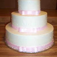 Mandy's Wedding This 6-10-14 wedding cake is covered with buttercream and accented with pink ribbon. The couples initials also accent the cake. This is a...