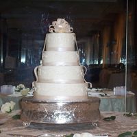 Day Wedding This 4-tier wedding cake is covered in buttercream and accented with fondant ribbons and a fondant/gumpaste bow. The fondant is painted...