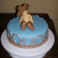 Baby Cowboy Cake Cake made for one year old's birthday. His daddy is a farrier, hence the horse shoes and rope. Baby is wearing daddy's oversized...