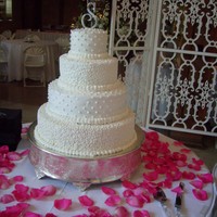 Elegance Alternating tiers of cornelli lace & dots with simple silver initial topper. Scattered rose petals.
