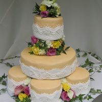 Stacked Satalite Cakes The champagne buttercream cakes were wrapped in fondant and then odorned with fonant flowers.