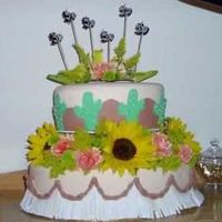 Western Themed Birthday Cake Oval shaped cake pans; fondant covered; fondant twisted ropes; fondant "fringe" with fresh flowers for a memorable western 50th...