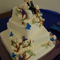Spring Wedding Cake A three tier square wedding cake covered in fondant, with gumpaste flowers and butterflies.