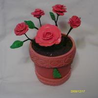 Red Roses flower of gum paste base of pot made of fondant and oreo dirt and inside of pot chocolate candy.
