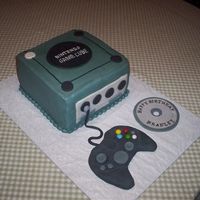 Game Cube Cake is buttercream with fondant accents. The remote is actually an XBox remote. She changed her mind after it was made. My son actually...