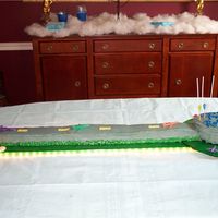 Runway Cake Round cake for terminal, 13x9 cake cut into thirds and placed end-to-end for runway. Rope lights wrapped around cake board for landing...