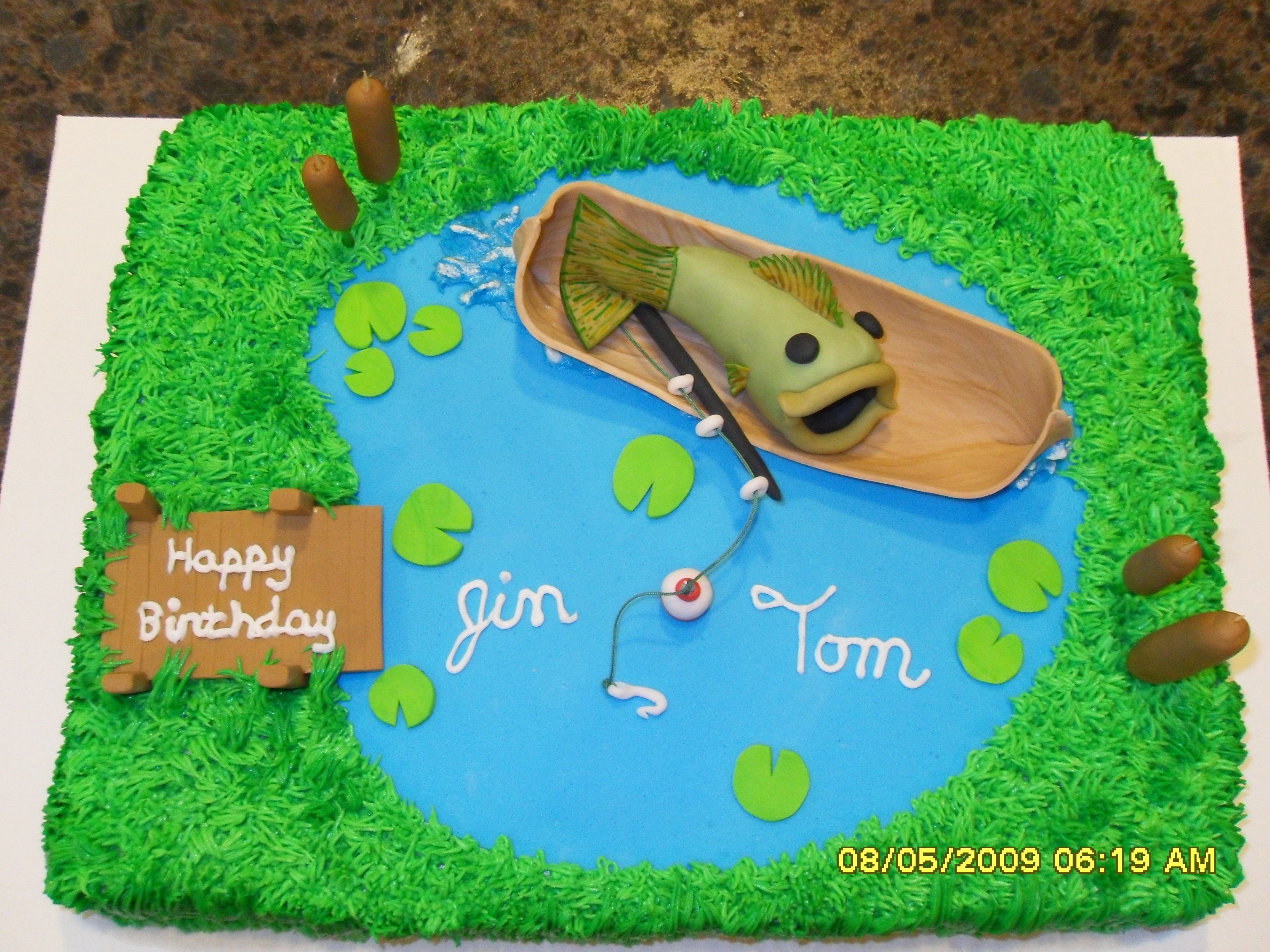 Let The Fish Do The Fishing! The lake, cattails, fish, canoe and dock is fondant and the grass is buttercream icing.