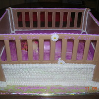 Sleeping Baby Girl Marble cake covered in Buttercream. The crib sides are Royal Icing and the baby is made of fondant.