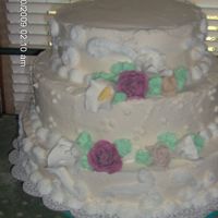 Round Wedding this was a three tiered cake, bottom was almond, then vanilla and top was chocolate iced in buttercream with scroll work and fondant roses...