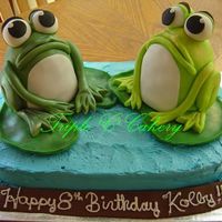 Rrrrribbit!!! 9x13 base cake iced with IMBC. Frogs are made in the mini wondermold pan, iced wth IMBC and covered with fondant. Frogs copied after ones...