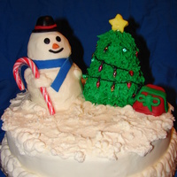 Snowman snowman and tree where made out of vanilla pound cake covered with BCF.the star and face,hat,and gift are fondant.. The lights on the tree...