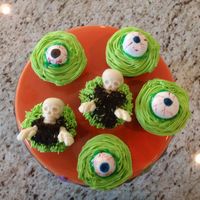 Spooky Cupcakes Orange creamsicle cupcakes, buttercream iced, eyeballs are fondant painted with Amerigels, Skulls are candy molds