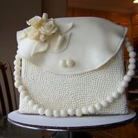 White Pearl Purse Cake This is my first purse cake. The cake is butter cake covered with chocolate fondant. some decorations are made with fondant and some...