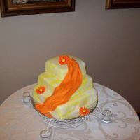 First Wedding Cake My friend asked for Marbled white and yellow fondant covered square cakes, stacked any way I chose. With a Orange daisies to match her...
