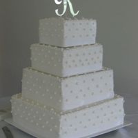 Swiss Dots W/ Ribbon Border White buttercream frosting with swiss dots and a white satin riboon trip