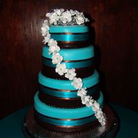 Wedding Cake Covered in chocolate and teal fondant with gumpaste flowers. Yellow cake with strawberry mousse, fresh strawberries and covered in...