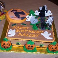 Halloween Birthday Cake Haunted house with the little girl flying on a broom across the moon. The ghost's & head stones are cookies covered with fondant,...