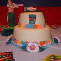 Hawaiian Theme Cake for a Hawaii themed birthday party. Strawberry cake w/ buttercream covered in tinted fondant. Flowers and tiki masks made of gumpaste...