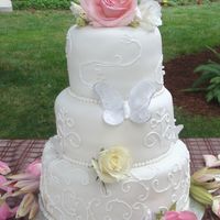 Butterflies And Scrolls Fondant covered cakes with royal icing scroolwork, edible butterflies, and fresh flowers.
