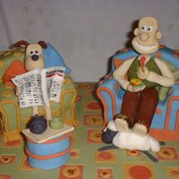 Wallace And Gromit I made this as a raffle prize for the school fair. The armchairs are madiera cake covered in fondant, and the rest is just fondant!