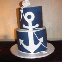 Tessa 3 layer cakes 8" and 6". Buttercream covered in navy blue fondant. White fondant anchor and gum paste rose. Rope is fabric trim...