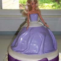 Barbie Chocolate cake under Barbie dress covered in MMF, sitting on top of a 10' round yellow cake with chocolate bc, covered in MMF