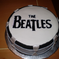 Beatles Drum Bass drum with Beatles logo on it. Fondant covered chocolate cake. Logo created by stencil and painting food coloring.