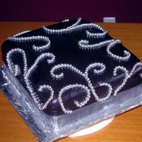 Black And Silver Scrolls Fudgy Chocolate cake with white chocolate truffle filling. Black fondant and scrolls with silver dragees.