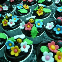 Cupcakes Chocolate cupcakes with chocolate ganache decorated with fondant flowers, bees and ladybugs.