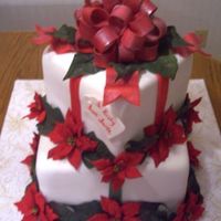 Gift Cake WASC covered in fondant with gumpaste bow and fondant ribbons. Flowers are silk.