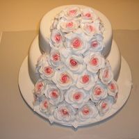 Wedding Cake With Fondant Roses And Leaves Bottom tier dark chocolate mud, top tier white chocolate mud cake covered in fondant with fondant roses.