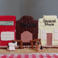 Western Town The cake is 3 layers of 12x 18. The false fronts are cardboard that is decoratored in buttercream. The sidewalk,windows, and doors of the...