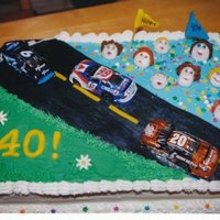 Birthday Cake For Nascar Fan faces and flags made from fondant, cars were foil covered chocalate i bought.