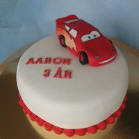 Lightning Mcqueen Vanilla sponge cake filled with strawberry mousse and raspberry mousse. Covered in sugar paste.I made McQueen in modeling paste.
