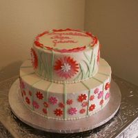 Daisy 2 tier stacked round iced in buttercream. Fondant accents of daisies and grass made from fondant.