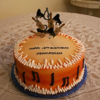Jonathon 10" round iced in buttercream and airbrush orange. Music notes and insturments are made from fondant.