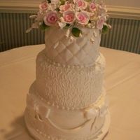 Brandywine Ii 3 tier fondant with drapes, cornelli lace, quilting w/ perals and gumpaste flowers.
