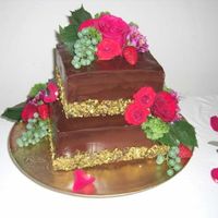 50Th chocolate hazelnut cake filled with gancahce and covered in chocolte glaze. Masked with chopped pistachio.