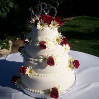 100_0369.jpg This cake was done onsite, with the flowers available. It was alot of fun using real flowers.